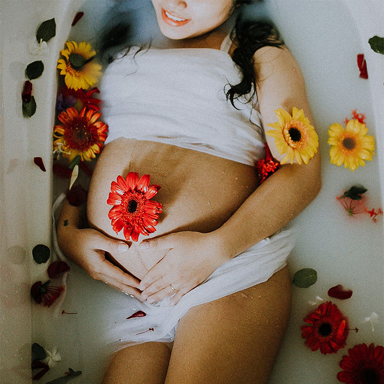 Ventre femme enceinte avec des fleurs.